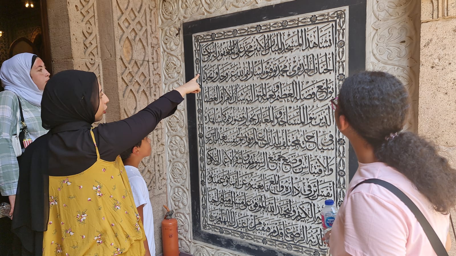 Traveller reading Islamic Cairo calligraphy with a local guide