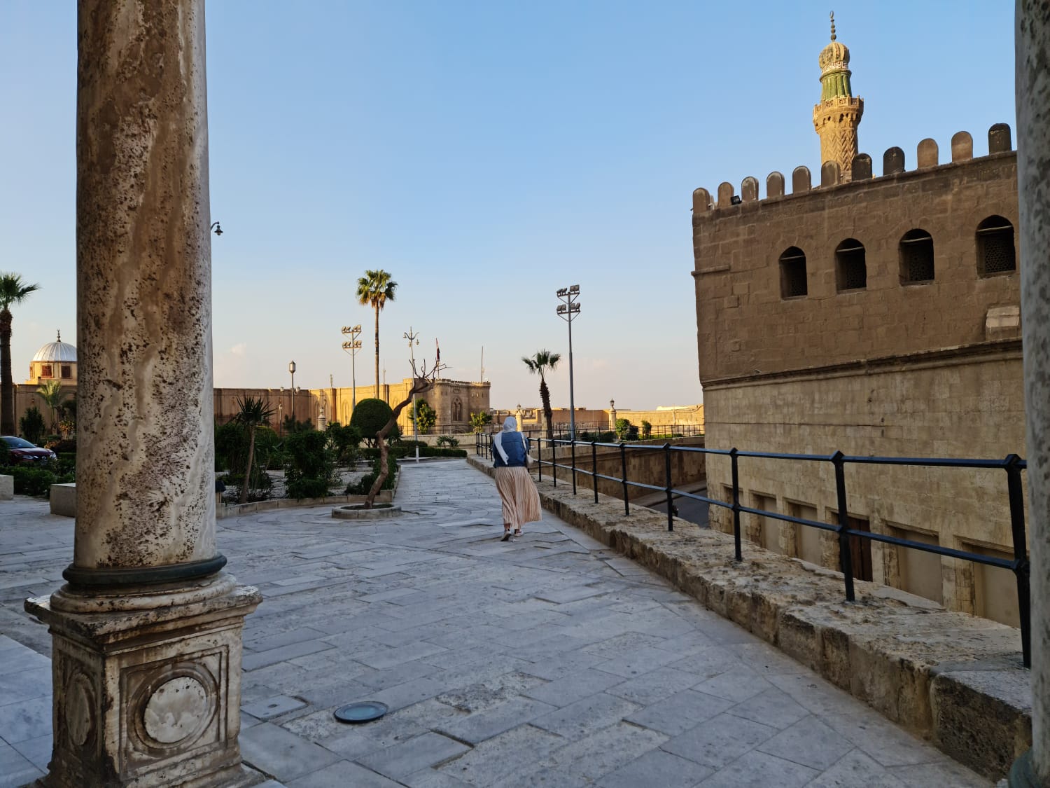 Traveller walking along the Citadel courtyard with minarets in view