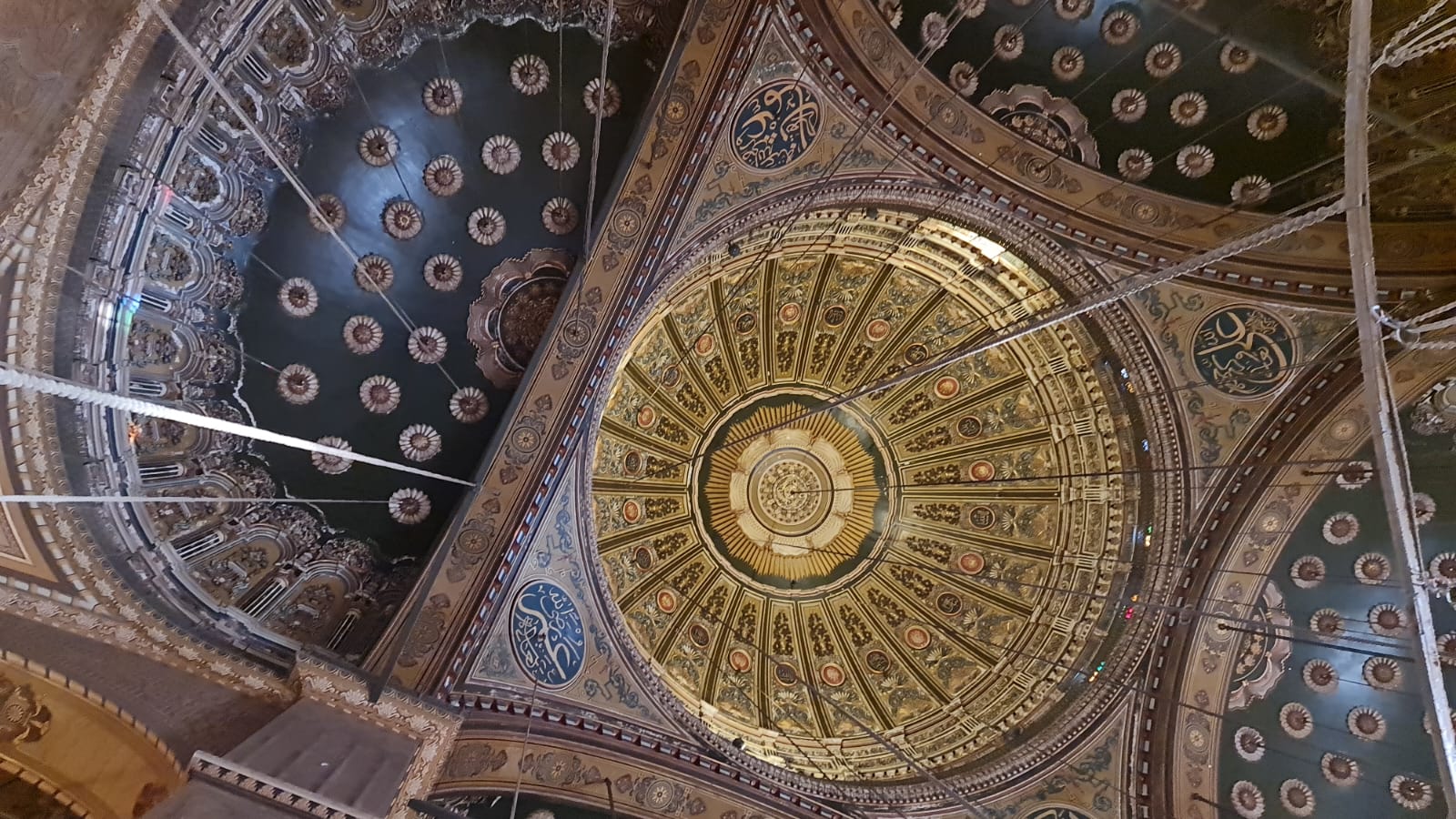 Ornate painted dome and chandeliers inside the Muhammad Ali Mosque