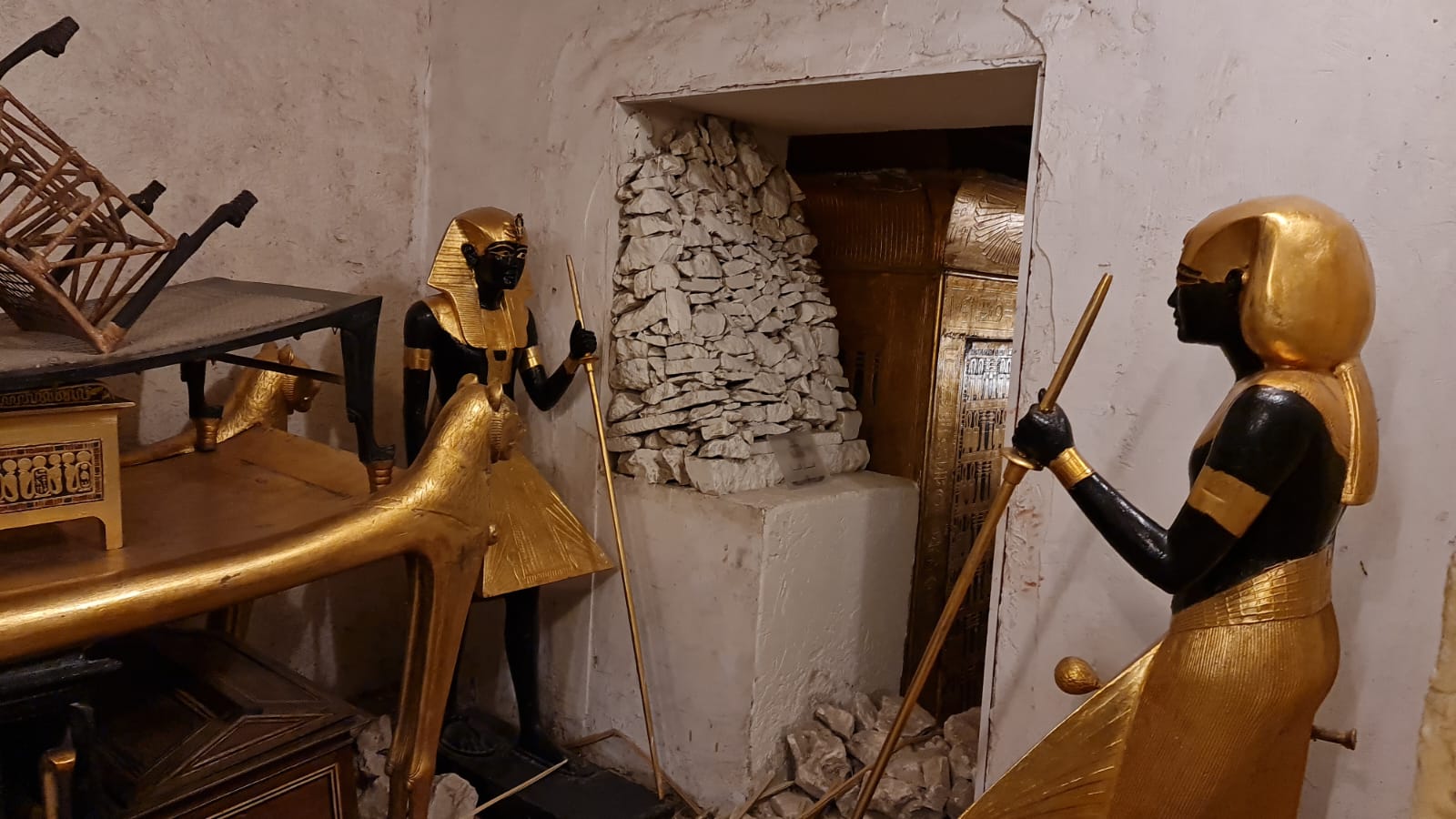 Inside the tomb of Tutankhamun with golden guardian statues in the Valley of the Kings